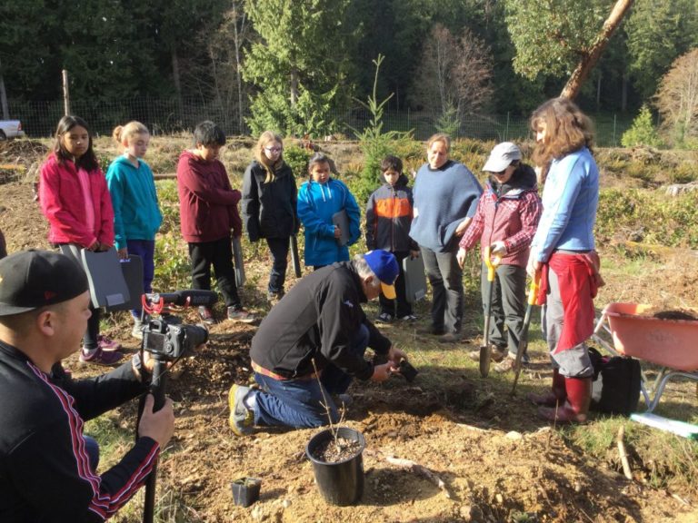 Penelakut elder Augie Sylvester planting a Garry Oak in the Forage Forest
